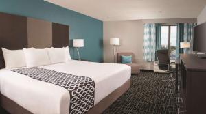 a hotel room with a bed, chair, and nightstand at La Quinta by Wyndham Atlanta Airport North in Atlanta