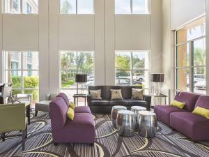 uma sala de estar com mobiliário roxo e janelas grandes em La Quinta by Wyndham Plantation at SW 6th St em Plantation