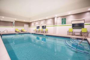 a pool in a hotel room with chairs at La Quinta by Wyndham Clifton Park in Clifton Park