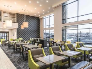 a restaurant with tables and chairs and windows at La Quinta Inn & Suites by Wyndham Walla Walla in Walla Walla