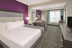 a hotel room with a large bed and a desk at La Quinta by Wyndham Springfield IL in Springfield