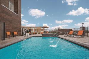 einen Pool mit einem Brunnen in der Mitte eines Gebäudes in der Unterkunft La Quinta by Wyndham Dallas Grand Prairie North in Grand Prairie