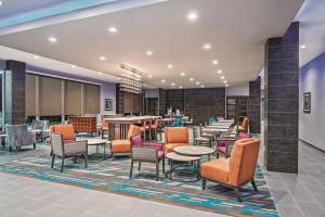 a lobby with chairs and tables and a bar at La Quinta by Wyndham Dallas Grand Prairie North in Grand Prairie