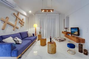 a living room with a blue couch and a tv at Ikia Aretousa in Kato Daratso