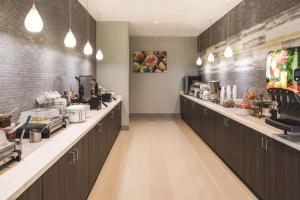 a restaurant kitchen with a long line of counters at La Quinta Inn & Suites by Wyndham Atlanta South - McDonough in McDonough