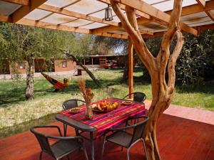 a table and chairs on a patio with a tree at Terra Luna Atacama in San Pedro de Atacama +36 photos