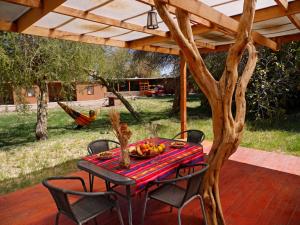 a table and chairs on a patio with a tree at Terra Luna Atacama in San Pedro de Atacama