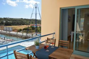 een balkon met een tafel met wijnglazen erop bij Stunning Apartment with Marina Views in Albufeira