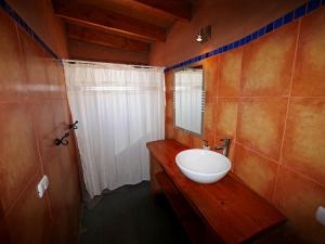 a bathroom with a white sink and a mirror at Terra Luna Atacama in San Pedro de Atacama