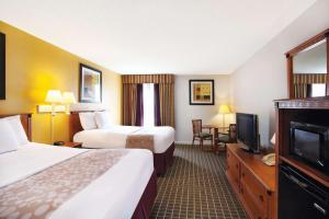 a hotel room with two beds and a flat screen tv at La Quinta Inn by Wyndham Orlando International Drive North in Orlando