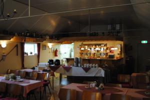 a dining room with tables and chairs and a bar at B&B Warnstee in Wichmond
