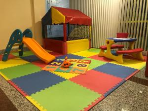 a childs play area with a playground and a swing at Hotel Brisa Tropical De Macaé in Macaé