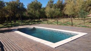 a swimming pool on a wooden deck with a fence at Terra Luna Atacama in San Pedro de Atacama