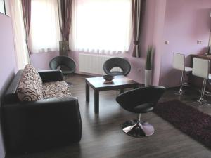 sala de estar con sofá, sillas y mesa en Alpha Apartman Sárvár, en Sárvár