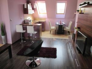 a living room with a kitchen and a dining room at Alpha Apartman Sárvár in Sárvár