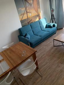 a living room with a blue couch and a table at Fok Sztormowy in Hel