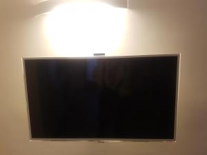 a flat screen television with a light on the wall at Open Space Aldobrandini in Lido di Ostia