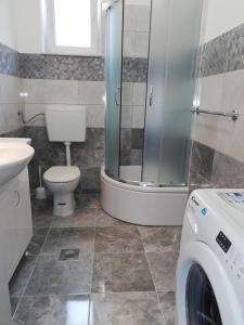 a bathroom with a toilet sink and a washing machine at Romantic New Superior Apartment Palma about 150m to Sandy beach in Crikvenica
