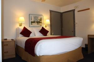 una habitación de hotel con una cama grande con almohadas rojas en St Moritz Lodge and Condominiums, en Aspen