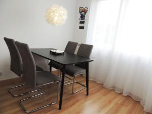 mesa de comedor con 4 sillas y lámpara de araña en Precioso piso en Oviedo, Parking, Wifi y Netflix By DeLabra Apartments, en Oviedo