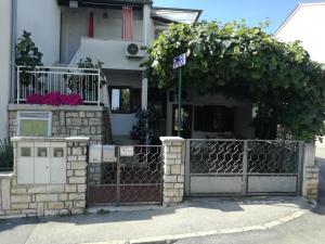 una cerca frente a una casa con flores en Vile Park Studio Apartments, en Poreč