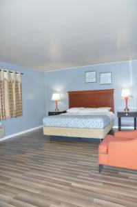 a bedroom with a bed and a couch and a chair at Glass Slipper Inn - Stanford Palo Alto in Palo Alto