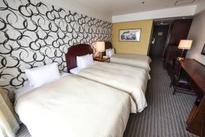 מיטה או מיטות בחדר ב-Rose Hotel Yokohama, The Distinctive Collection By WORLDHOTELS