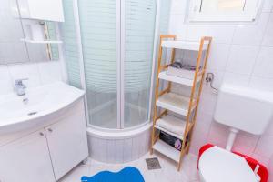 ein Badezimmer mit Dusche, Toilette und Waschbecken in der Unterkunft Apartments Ive i Maja in Ražanj