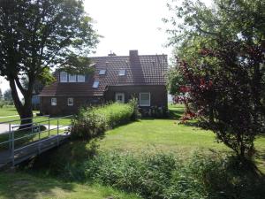 una casa con un patio de hierba delante de ella en 50141 Gretchen´s Hus 1, en Wangerland