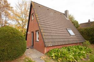 una pequeña casa de ladrillo rojo con techo negro en 50156..., en Harlesiel
