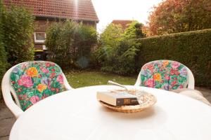 ein weißer Tisch und Stühle mit einem Buch darüber in der Unterkunft 50158... in Carolinensiel + 12 Fotos