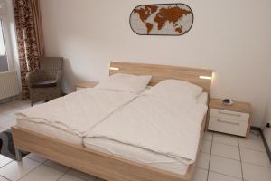 een slaapkamer met een houten bed met witte lakens bij 50140... in Carolinensiel