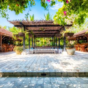 a pavilion with a bench in a courtyard at Hotel Komune and Beach Club Bali in Keramas