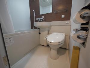 La petite salle de bains est pourvue de toilettes et d'un lavabo. dans l'établissement Hotel Route-Inn Grand Ota Ekimae, à Ota