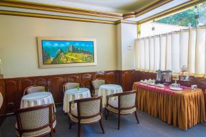 a restaurant with tables and chairs and a painting on the wall at Hotel Lexus in Lima