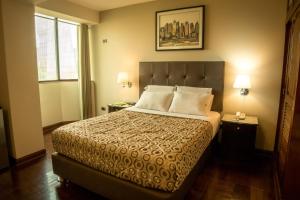 1 dormitorio con 1 cama, 2 lámparas y ventana en Hotel Lexus en Lima