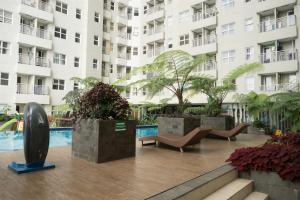a large apartment building with a pool in front of it at Direct Access to Pool 2BR Apartment at Parahyangan Residence By Travelio in Bandung +6 photos