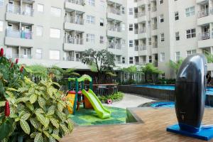 a playground in front of a large apartment building at Direct Access to Pool 2BR Apartment at Parahyangan Residence By Travelio in Bandung