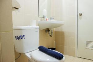 a bathroom with a toilet and a sink at Direct Access to Pool 2BR Apartment at Parahyangan Residence By Travelio in Bandung