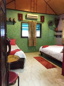 een slaapkamer met 2 bedden en een tafel en een stoel bij Shanti Lodge in Bangkok
