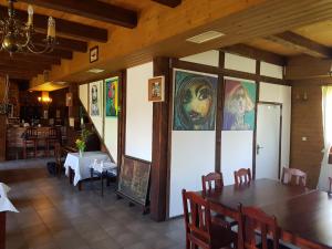 a restaurant with a table and chairs and paintings on the walls at Jasminum in Słupsk
