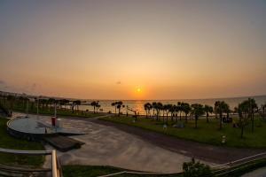 a sunset over the ocean with a skate park at Pine House in ARAHA in Chatan