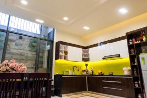 a kitchen with yellow and white cabinets at Lama Homestay in Hue