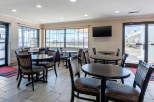 een restaurant met tafels en stoelen en een flatscreen-tv bij Econo Lodge in Lexington