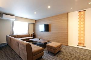 a living room with a couch and a table at HOTEL COCON in Fukuoka