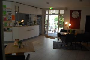 a kitchen and dining room with a clock on the wall at Stadthotel am Bühnenhaus in Kevelaer