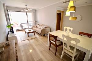 een keuken en een woonkamer met een tafel en stoelen bij Estrella del Mar 68 in Denia