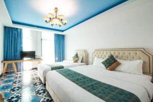 a hotel room with two beds and a chandelier at Hotel Hilal in Cyberjaya