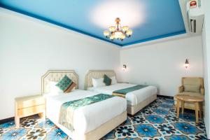 a hotel room with two beds and a chandelier at Hotel Hilal in Cyberjaya