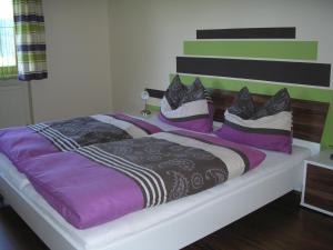 1 dormitorio con 1 cama grande con almohadas moradas y negras en Haus Oberhaslach, en Abtenau